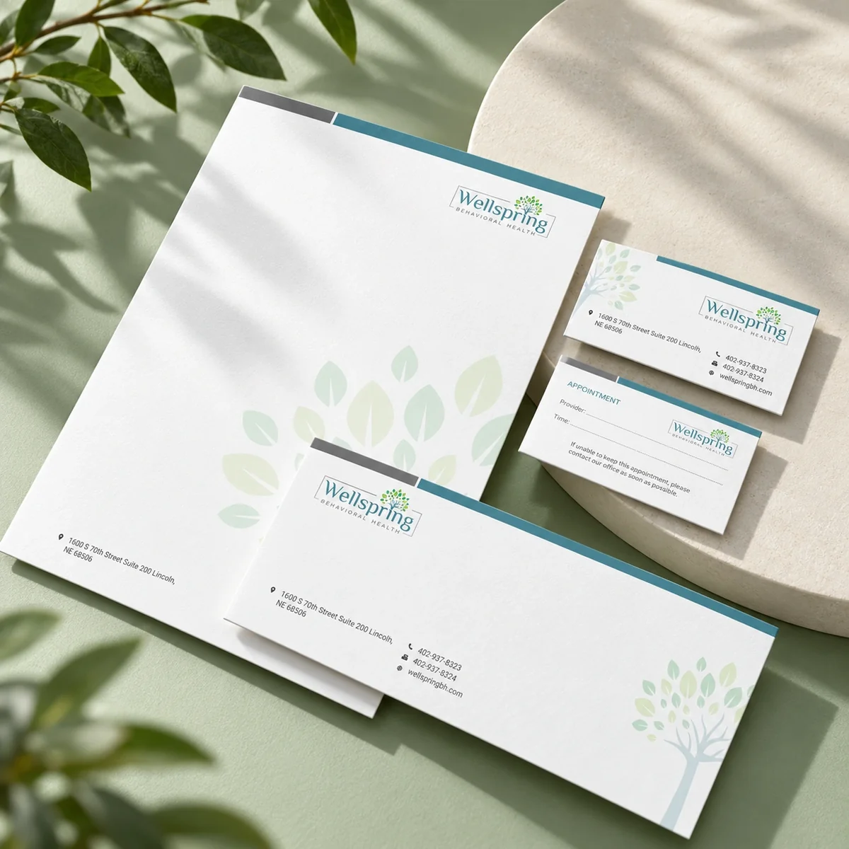 Wellspring letterhead, envelope and business cards with teal and botanical details